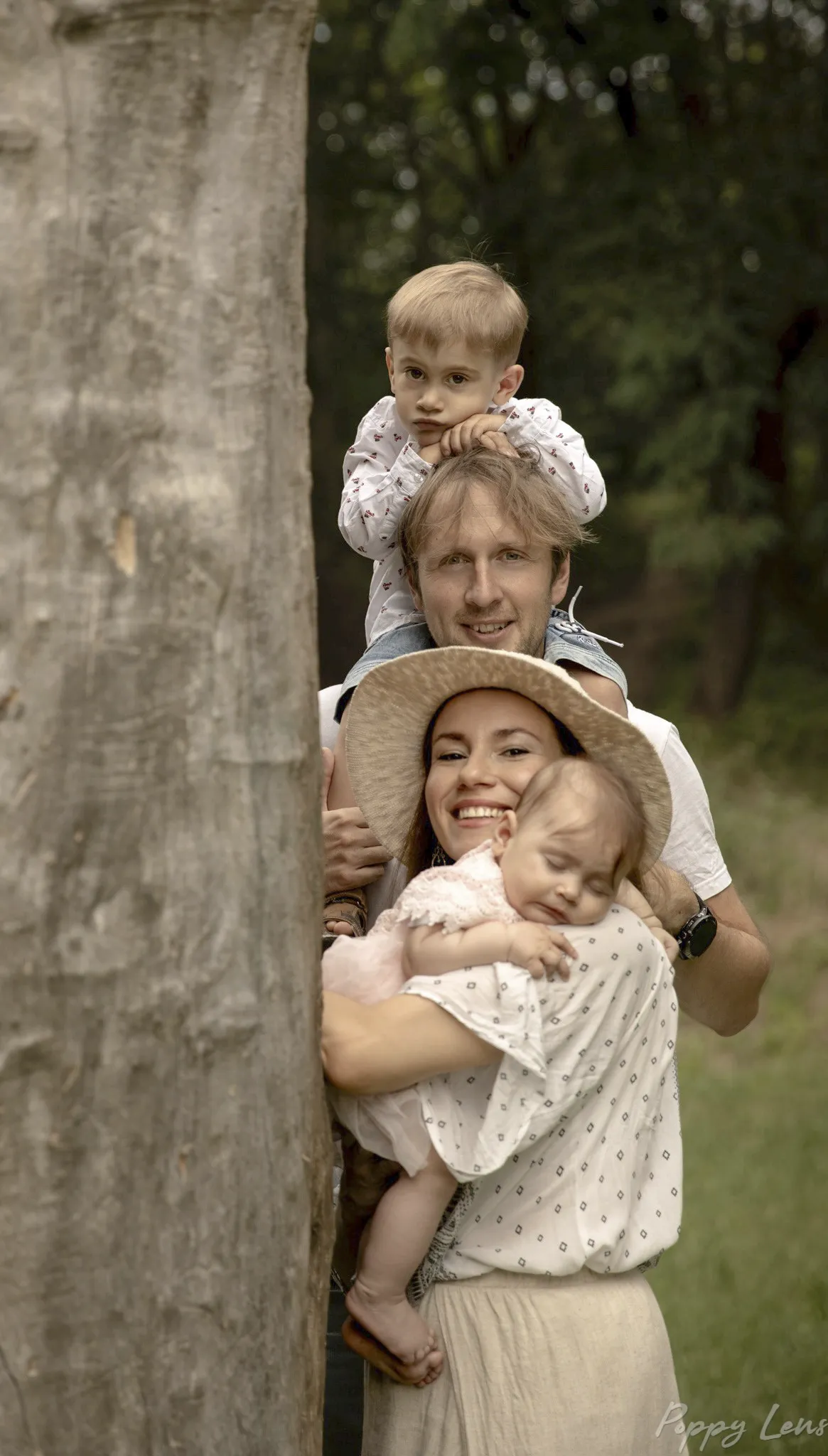 A family portrait where the members heads are visible top to bottom: a young boy, a father, a mother and a baby